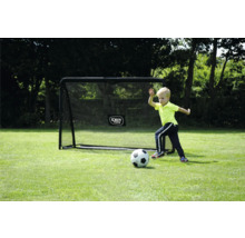Enfant jouant au football devant un but de foot EXIT TOYS noir sur une pelouse avec des arbres en arrière-plan.