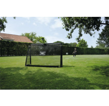 But de football EXIT Toys sur une pelouse dans un jardin avec un enfant tirant dans un ballon de foot.