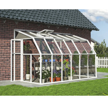 Anlehngewächshaus mit weißem Aluminiumrahmen und Glaspaneelen an einer Ziegelwand, mit verschiedenen Topfpflanzen und Blumen im Inneren.