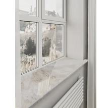 Helle Fensterbank in Natursteinoptik unter einem weißen Fensterrahmen mit Ausblick auf historische Mauern.