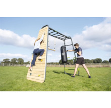 Station de fitness extérieure EXIT Toys GetSet en métal et bois avec mur d escalade, sac de frappe et espalier dans un jardin.