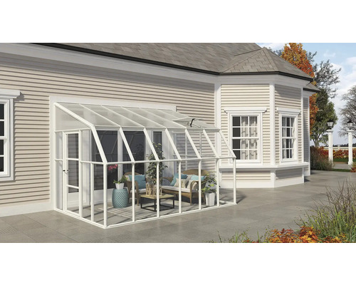 An das Haus angebautes weißes Anlehngewächshaus aus Glas, eingerichtet mit Gartenmöbeln und Pflanzen auf einer Terrasse.