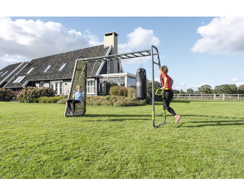 Station de fitness extérieure et portique de jeux avec échelle de singe, balançoire, anneaux de gymnastique et sac de frappe dans un grand jardin.