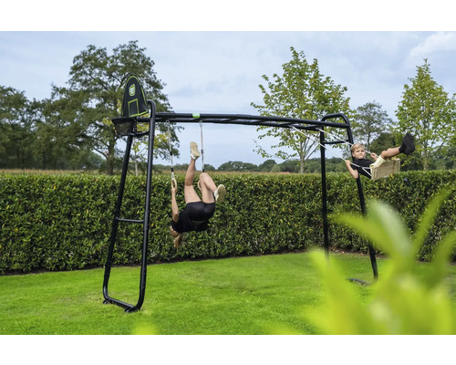 Portique de jeu en métal noir avec balançoire, anneaux de gymnastique et panier de basket dans un jardin avec des enfants qui jouent.