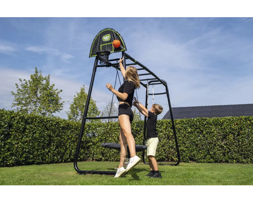 Portique en métal lumineux et organisé avec panier de basket, balançoire nid et échelle. Une femme et un enfant jouent au basket. EXIT Toys Logo.
