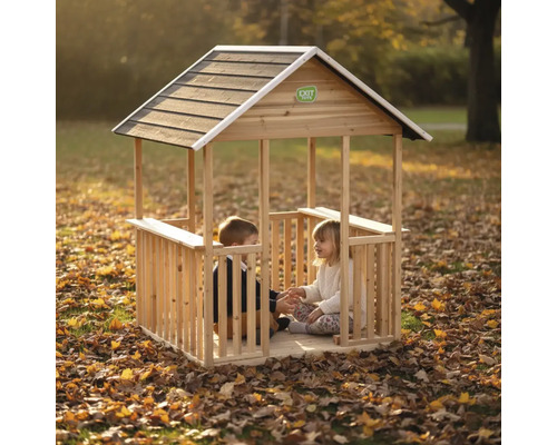 Holz-Spielhaus für Kinder von EXIT Toys mit offenem Design und Satteldach, zwei Kinder sitzen im Inneren im herbstlichen Garten.