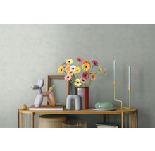Décoration de buffet moderne avec des gerberas colorés dans un vase, une sculpture de chien ballon, un cadre en bois et des bougeoirs.