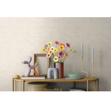 Intérieur moderne avec buffet en bois, bouquet de gerberas, sculpture de chien ballon, chandeliers et cadre photo devant un mur clair.