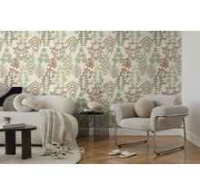 Modernes Wohnzimmer mit Vliestapete im Blättermuster, weißem Sofa mit Decke und grauem Sessel auf Parkettboden.