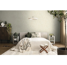 Hell eingerichtetes Schlafzimmer mit Bett, gemusterten Kissen, zwei weißen Nachttischen, einer Pendelleuchte und strukturierten Tapeten an der Wand.