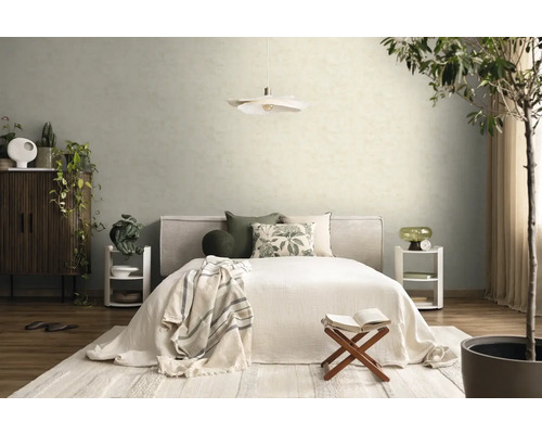 Hell eingerichtetes Schlafzimmer mit Bett, gemusterten Kissen, zwei weißen Nachttischen, einer Pendelleuchte und strukturierten Tapeten an der Wand.