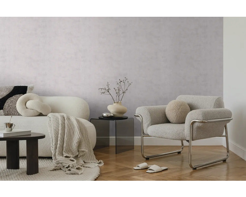 Modernes Wohnzimmer mit strukturierter hellgrauer Tapete, weißem Sofa, grauem Sessel mit Metallgestell und hellem Parkettboden.