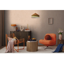 Modern agericht Wunnzëmmer mat orangefarbenem Drahtsessel, Polstersessel, donkelem Sideboard a ronnem Holzbeistelltisch virun enger hellgroer Mauer.