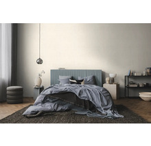 Chambre à coucher moderne et lumineuse avec un lit à tête de lit bleue à rainures verticales, du linge de lit bleu et un parquet en chevrons.