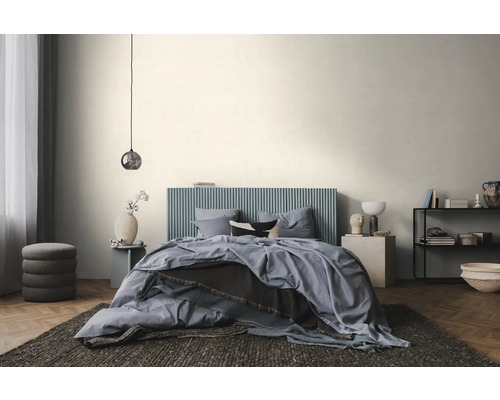 Chambre à coucher moderne et lumineuse avec un lit à tête de lit bleue à rainures verticales, du linge de lit bleu et un parquet en chevrons.