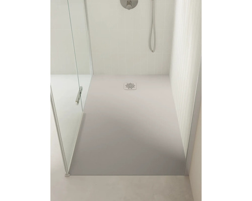 Douche à l'italienne moderne avec un grand receveur de douche rectangulaire, du carrelage clair et une paroi en verre.