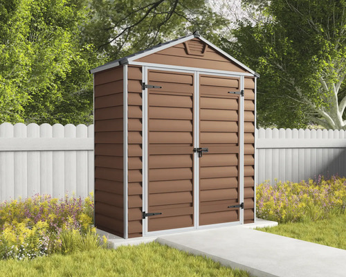 Abri de jardin marron en plastique aspect bois avec toit à deux versants et double porte dans un jardin devant une clôture.