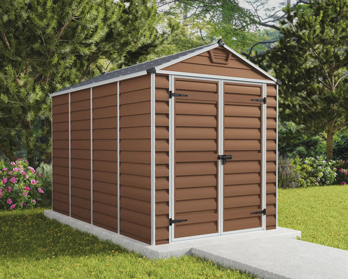 Abri de jardin brun avec toit à deux pans et double porte battante sur une fondation en béton clair dans un jardin soigné avec pelouse et arbres.