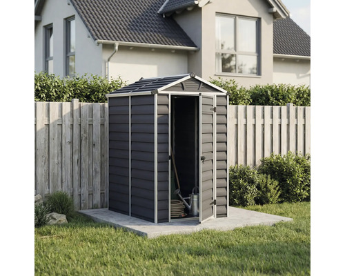 Abri de jardin compact en plastique anthracite avec toit à deux pans et porte ouverte, sur une base en béton à côté d une clôture en bois.