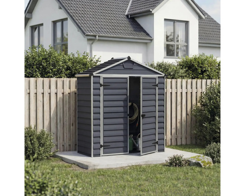 Abri de jardin en plastique anthracite avec toit à deux pans et double porte ouverte sur une base en béton dans un jardin lumineux et soigné.