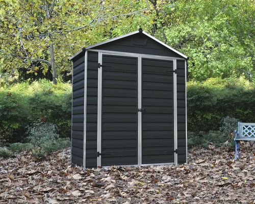 Abri de jardin en plastique gris foncé avec porte double et toit à deux pans dans un jardin.