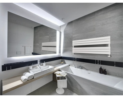 Salle de bain moderne avec carrelage gris, grand miroir éclairé, lavabo blanc, baignoire et radiateur sèche-serviettes horizontal.