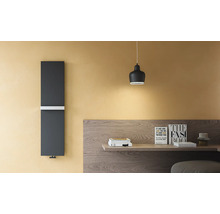 Radiateur design vertical gris foncé avec porte-serviette blanc sur un mur jaune à côté d'un bureau en bois.
