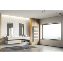 Salle de bains lumineuse avec double vasque, robinetterie noire, deux miroirs, mur carrelé blanc, grande fenêtre et sèche-serviettes.