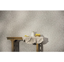 Papier peint intissé avec un motif vertical abstrait sur un mur derrière une table en bois avec un pichet et des citrons.