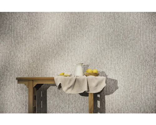 Papier peint intissé avec un motif vertical abstrait sur un mur derrière une table en bois avec un pichet et des citrons.