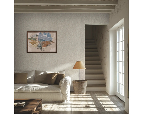 Salon lumineux avec papier peint texturé, canapé blanc, coussins marron, parquet, lampe sur un panier et escalier.