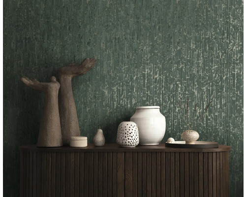 Papier peint vert foncé avec texture verticale derrière un buffet en bois sombre avec des vases décoratifs.
