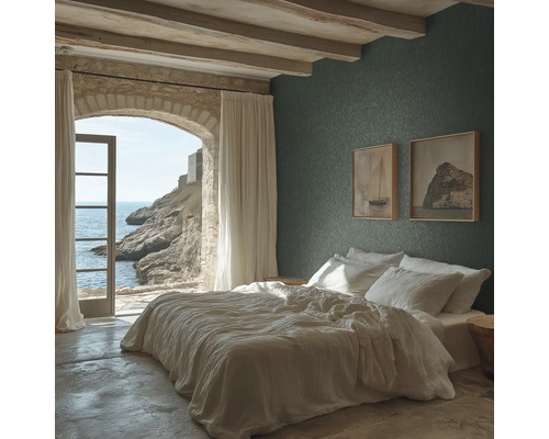 Chambre à coucher avec papier peint texturé vert foncé, lit blanc, plafond avec poutres en bois et une arche en pierre avec vue sur la mer.
