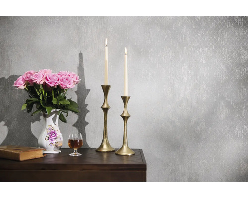 Papier peint intissé gris avec structure vintage et motif discret dans une scène classique avec chandeliers, fleurs et un livre.