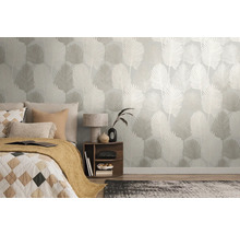 Chambre moderne avec papier peint intissé à motif botanique de feuilles de palmier, avec un lit, une table de chevet en bois et un tapis.