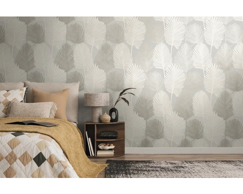 Chambre moderne avec papier peint intissé à motif botanique de feuilles de palmier, avec un lit, une table de chevet en bois et un tapis.