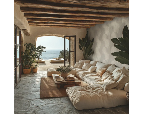 Salon rustique avec grand canapé modulable, poutres en bois au plafond, sol en pierre et vue sur la mer via une ouverture en arche.
