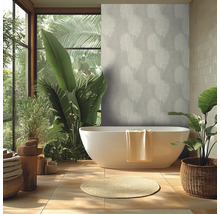 Salle de bains moderne et lumineuse avec baignoire en ilot, papier peint intisse au motif tropical, grandes plantes et carrelage.