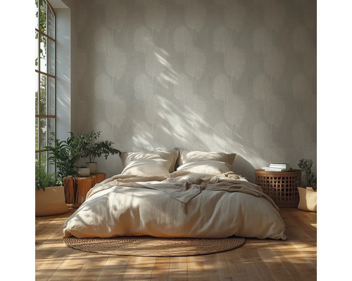 Chambre lumineuse avec papier peint à feuilles de palmier, parquet, lit avec linge de maison, tapis rond en jute et plantes d'intérieur.