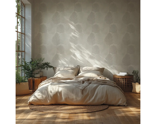 Chambre lumineuse avec papier peint à motif de feuilles, lit bas avec literie neutre sur un tapis rond en jute et accents en bois.