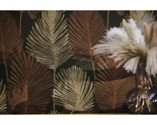 Vliestapete mit großflächigem Palmenblatt Muster in Gold und Bronze vor dunklem Hintergrund.