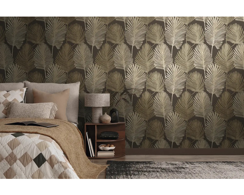 Papier peint intissé avec motif de grandes feuilles dans une chambre à coucher moderne avec lit et table de chevet.