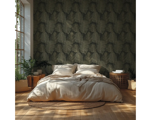 Chambre avec papier peint foncé à motif de feuilles, lit clair, tapis tressé, parquet et plantes d’intérieur sous une lumière vive.