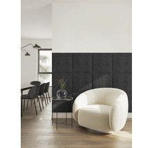 Modernes Wohnzimmer mit dunkelgrauen quadratischen Wandpaneelen, einem cremefarbenen Bouclé-Sessel und schwarzem Beistelltisch auf Holzfußboden.