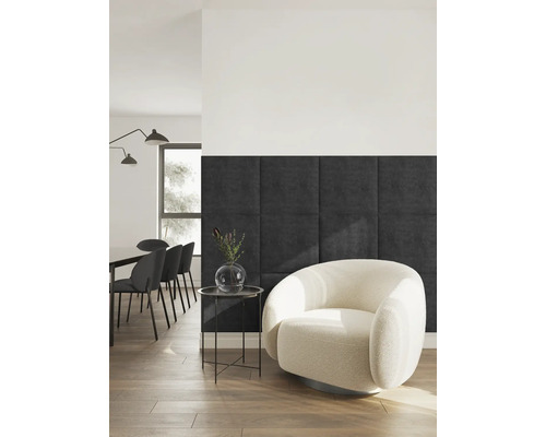 Modernes Wohnzimmer mit dunkelgrauen quadratischen Wandpaneelen, einem cremefarbenen Bouclé-Sessel und schwarzem Beistelltisch auf Holzfußboden.