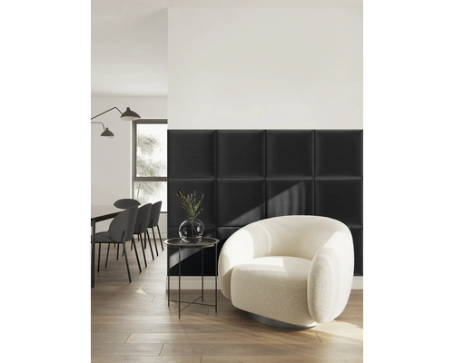 Pièce moderne avec des panneaux muraux rembourrés carrés noirs, un fauteuil arrondi blanc et un coin repas sur un sol en bois.