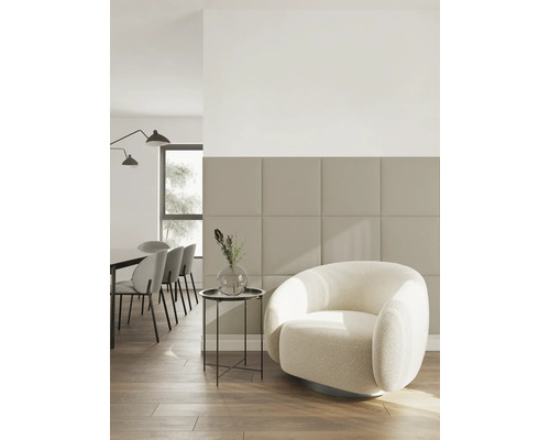 Salon moderne avec panneaux muraux carrés, fauteuil blanc et sol en bois dans un style minimaliste et lumineux.