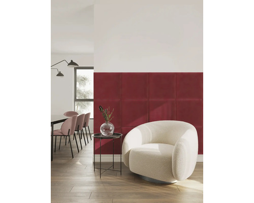 Moderne Wandgestaltung mit quadratischen, gepolsterten Wandpaneelen in Rot in einem hellen Wohnzimmer mit weißem Sessel.