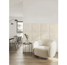 Salon moderne avec des panneaux muraux rembourrés carrés, un fauteuil rond et un coin repas dans une pièce lumineuse et organisée.