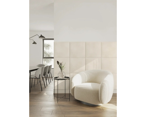 Salon moderne avec des panneaux muraux rembourrés carrés, un fauteuil rond et un coin repas dans une pièce lumineuse et organisée.